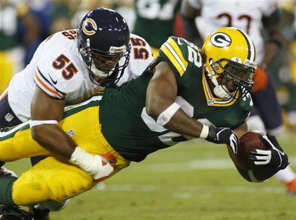 Green Bay Packers running back Cedric Benson (R) is tackled by Chicago Bears linebacker Lance Briggs in the first half during their NFL foot Green Bay Packers running back Cedric Benson (R) is tackled by Chicago Bears linebacker Lance Briggs in the first half during their NFL foot
