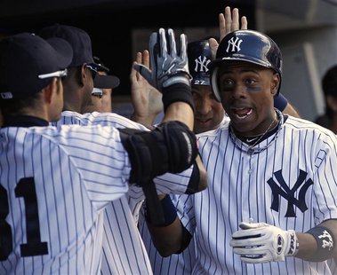 New York Yankees' Curtis Granderson (R) is congratulated by teammates after hitting a two-run home run against the Tampa Bay Rays during the New York Yankees' Curtis Granderson (R) is congratulated by teammates after hitting a two-run home run against the Tampa Bay Rays during the