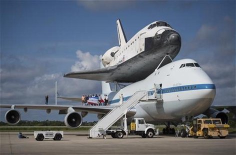 Workers pose for a photograph on the wing of NASA's Shuttle Carrier Aircraft, (SCA) with the space shuttle Endeavour mated on top, at the Ke Workers pose for a photograph on the wing of NASA's Shuttle Carrier Aircraft, (SCA) with the space shuttle Endeavour mated on top, at the Ke