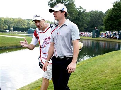 Rory McIlroy of Northern Ireland (R), talks with his caddie JP Fitzgerald (L), as they walk to the seventh green during the second round of Rory McIlroy of Northern Ireland (R), talks with his caddie JP Fitzgerald (L), as they walk to the seventh green during the second round of