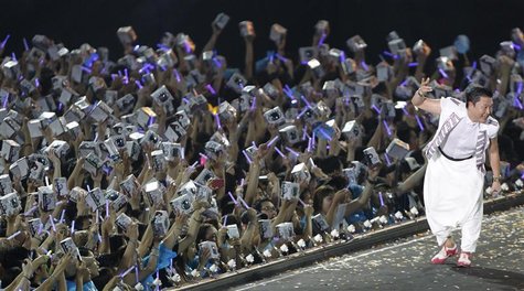 Singer Psy performs as fans hold up his music CDs during his concert in Seoul August 11, 2012. REUTERS/Lee Jae-Won Singer Psy performs as fans hold up his music CDs during his concert in Seoul August 11, 2012. REUTERS/Lee Jae-Won
