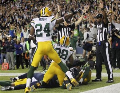 Seattle Seahawks wide receiver Golden Tate (bottom, obscured) catches the 14-12, game-winning touchdown in the endzone while he is swarmed by Green Bay Packers' Jarrett Bush (24) and Tramon Williams (38) during the final eight seconds of the fourth quarter of their Monday night NFL football game at Centurylink Field in Seattle, Washington, September 24, 2012. REUTERS/Anthony Bolante Seattle Seahawks wide receiver Golden Tate (bottom, obscured) catches the 14-12, game-winning touchdown in the endzone while he is swarmed by Green Bay Packers' Jarrett Bush (24) and Tramon Williams (38) during the final eight seconds of the fourth quarter of their Monday night NFL football game at Centurylink Field in Seattle, Washington, September 24, 2012. REUTERS/Anthony Bolante