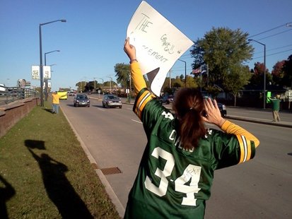 Packers fan Tamie Vertz holds a sign along Lombardi Avenue in front of Lambeau Field. (courtesy of FOX 11). Packers fan Tamie Vertz holds a sign along Lombardi Avenue in front of Lambeau Field. (courtesy of FOX 11).