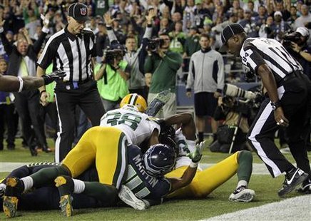 Referees wait to make the call on whether Seattle Seahawks wide receiver Golden Tate (bottom, obscured) caught the game winning touchdown against the Green Bay Packers in the fourth quarter of their NFL football game in Seattle, Washington, September 24, 2012. Credit: Reuters/Anthony Bolante Referees wait to make the call on whether Seattle Seahawks wide receiver Golden Tate (bottom, obscured) caught the game winning touchdown against the Green Bay Packers in the fourth quarter of their NFL football game in Seattle, Washington, September 24, 2012. Credit: Reuters/Anthony Bolante