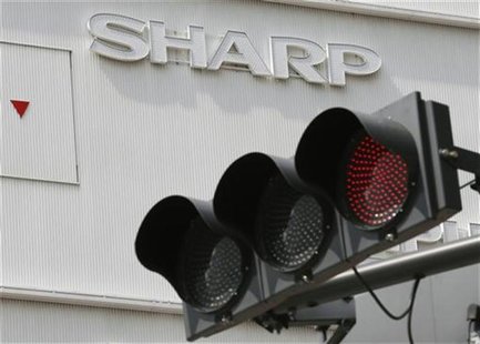 Sharp's logo is seen behind a traffic sign outside an electronics shop in Tokyo September 7, 2012. REUTERS/Kim Kyung-Hoon Sharp's logo is seen behind a traffic sign outside an electronics shop in Tokyo September 7, 2012. REUTERS/Kim Kyung-Hoon