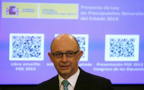 Spain's Treasury Minister Cristobal Montoro stands in front of a screen showing a document with a Quick Response (QR) code, representing the Spain's Treasury Minister Cristobal Montoro stands in front of a screen showing a document with a Quick Response (QR) code, representing the