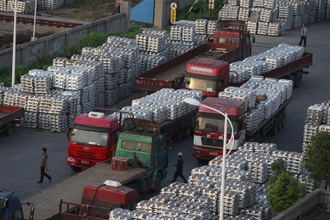 Workers walk through an aluminium ingots depot in Wuxi, Jiangsu province September 26, 2012. China's official manufacturing managers' index Workers walk through an aluminium ingots depot in Wuxi, Jiangsu province September 26, 2012. China's official manufacturing managers' index