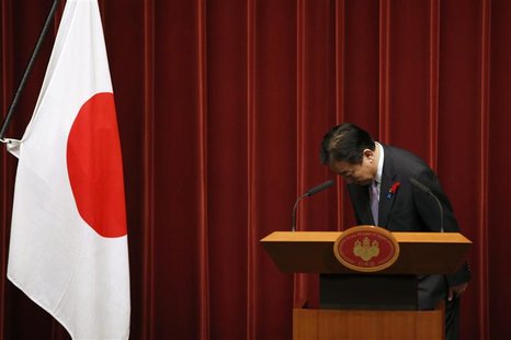 Japan's Prime Minister Yoshihiko Noda bows next to a Japanese national flag during a news conference at his official residence in Tokyo Octo Japan's Prime Minister Yoshihiko Noda bows next to a Japanese national flag during a news conference at his official residence in Tokyo Octo