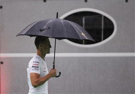 Mercedes Formula One driver Michael Schumacher of Germany walks through the paddock as it rains ahead of the first practice session of the S Mercedes Formula One driver Michael Schumacher of Germany walks through the paddock as it rains ahead of the first practice session of the S