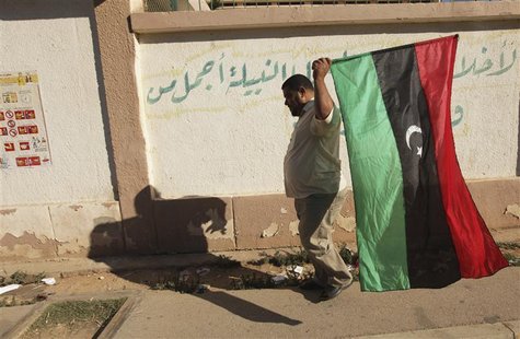 A man carries a Kingdom of Libya flag as he goes to vote in the National Congress election, in Benghazi July 7, 2012. REUTERS/Esam Al-Fetori A man carries a Kingdom of Libya flag as he goes to vote in the National Congress election, in Benghazi July 7, 2012. REUTERS/Esam Al-Fetori
