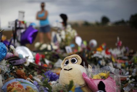 A stuffed animal peeks out from a mound of others at the marker for 6-year-old victim Veronica Moser-Sullivan at a memorial for the theater- A stuffed animal peeks out from a mound of others at the marker for 6-year-old victim Veronica Moser-Sullivan at a memorial for the theater-