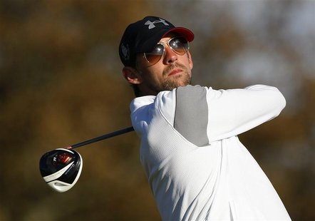 Olympic swimming champion Michael Phelps from the U.S. watches his drive at the 13th hole during the second round of the Dunhill Links golf Olympic swimming champion Michael Phelps from the U.S. watches his drive at the 13th hole during the second round of the Dunhill Links golf