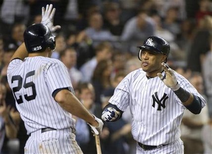 New York Yankees batter Robinson Cano celebrates with teammate Mark Teixeira (25) after he hit a two-run home run, his second of the game, a New York Yankees batter Robinson Cano celebrates with teammate Mark Teixeira (25) after he hit a two-run home run, his second of the game, a