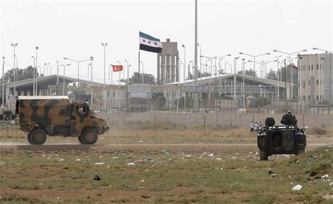 Turkish troops take their position at the Akcakale border gate in southern Sanliurfa province October 7, 2012, as a Syrian Independence flag Turkish troops take their position at the Akcakale border gate in southern Sanliurfa province October 7, 2012, as a Syrian Independence flag