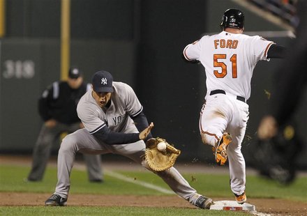 New York Yankees' Mark Teixeira (L) makes a catch to force out Baltimore Orioles' Lew Ford (R) at first base after Ford hit a sacrifice bunt New York Yankees' Mark Teixeira (L) makes a catch to force out Baltimore Orioles' Lew Ford (R) at first base after Ford hit a sacrifice bunt