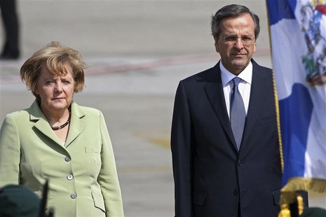 Germany's Chancellor Angela Merkel is welcomed by Greece's Prime Minister Antonis Samaras (R) upon arrival at Eleftherios Venizelos airport Germany's Chancellor Angela Merkel is welcomed by Greece's Prime Minister Antonis Samaras (R) upon arrival at Eleftherios Venizelos airport