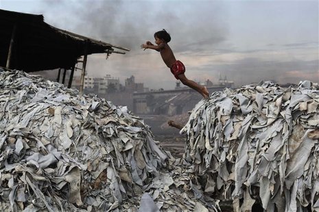 A child jumps on the waste products that are used to make poultry feed as she plays in a tannery at Hazaribagh in Dhaka October 9, 2012. REU A child jumps on the waste products that are used to make poultry feed as she plays in a tannery at Hazaribagh in Dhaka October 9, 2012. REU