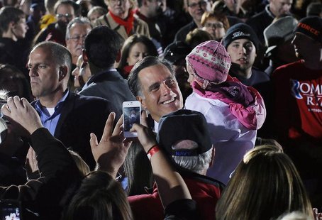 Republican presidential nominee Mitt Romney carries a child after speaking at a campaign rally outside the Cuyahoga Falls Natatorium in Cuya Republican presidential nominee Mitt Romney carries a child after speaking at a campaign rally outside the Cuyahoga Falls Natatorium in Cuya