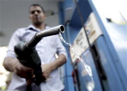 A worker holds up a fuel pump nozzle after filling up the tank of a car at a petrol station in Cairo October 3, 2012. REUTERS/Mohamed Abd El A worker holds up a fuel pump nozzle after filling up the tank of a car at a petrol station in Cairo October 3, 2012. REUTERS/Mohamed Abd El
