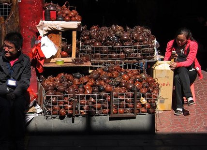 Vendors selling tea pots and sculptures sit next to their stalls as they wait for customers at a small market in central Beijing October 11, Vendors selling tea pots and sculptures sit next to their stalls as they wait for customers at a small market in central Beijing October 11,
