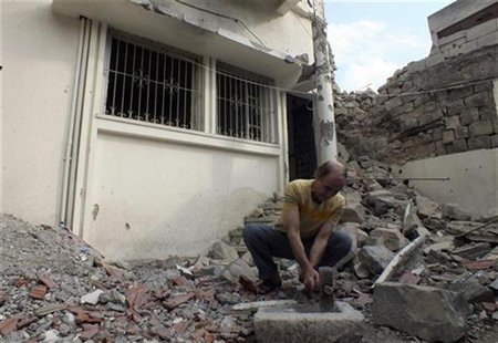 A man works in front of a damaged house near Homs October 9, 2012. Picture taken October 9, 2012 REUTERS/Yazan Homsy A man works in front of a damaged house near Homs October 9, 2012. Picture taken October 9, 2012 REUTERS/Yazan Homsy