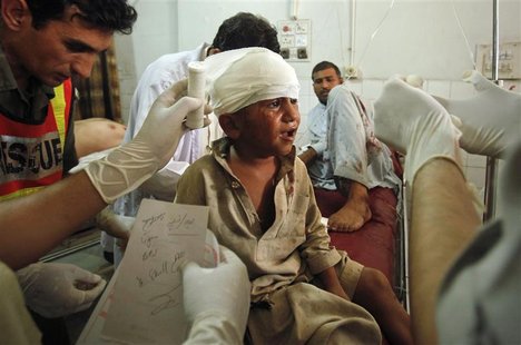 Paramedics and a rescue worker attend to a child who was wounded in a suicide bomb attack in Darra Adam Khel, after he was brought to the La Paramedics and a rescue worker attend to a child who was wounded in a suicide bomb attack in Darra Adam Khel, after he was brought to the La