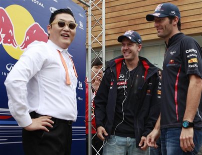 South Korean singer Psy (L), Red Bull Formula One driver Sebastian Vettel (C) of Germany and teammate Mark Webber of Australia talk after pe South Korean singer Psy (L), Red Bull Formula One driver Sebastian Vettel (C) of Germany and teammate Mark Webber of Australia talk after pe