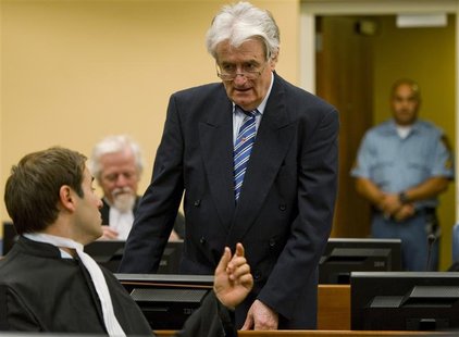 Former Bosnian Serb leader Radovan Karadzic talks to member of his legal team Marko Sladojevic in the courtroom on the first day of his defe Former Bosnian Serb leader Radovan Karadzic talks to member of his legal team Marko Sladojevic in the courtroom on the first day of his defe