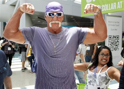 Wrestler Hulk Hogan poses for a photo as a fan also poses as he walks in the Los Angeles Convention Center while on site to promote Majesco Wrestler Hulk Hogan poses for a photo as a fan also poses as he walks in the Los Angeles Convention Center while on site to promote Majesco