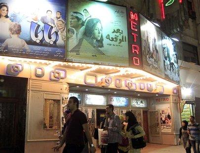 People walk past a poster of the movie "After the Battle" outside a cinema in Cairo October 16, 2012. When horse and camel riders attacked p People walk past a poster of the movie "After the Battle" outside a cinema in Cairo October 16, 2012. When horse and camel riders attacked p