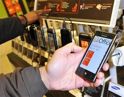 A customer views a mobile phone with the new Windows 7 operating system after its arrival in British shops, in central London October 21, 20 A customer views a mobile phone with the new Windows 7 operating system after its arrival in British shops, in central London October 21, 20