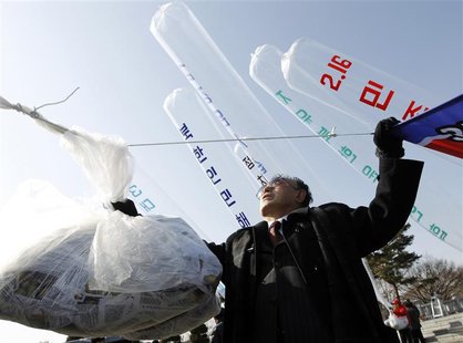 An anti-North Korea activist (front) and North Korean defectors, who are now legal South Korean citizens, prepare to release balloons contai An anti-North Korea activist (front) and North Korean defectors, who are now legal South Korean citizens, prepare to release balloons contai