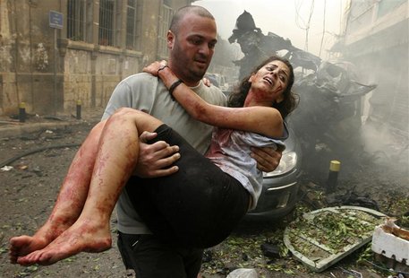 A wounded woman is carried at the site of an explosion in Ashrafieh, central Beirut, October 19, 2012. At least two people were killed and 1 A wounded woman is carried at the site of an explosion in Ashrafieh, central Beirut, October 19, 2012. At least two people were killed and 1
