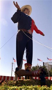 Workers move the boot portion (lower left) of the "Big Tex" cowboy statue during the assembly process at the entrance to The State Fair of T Workers move the boot portion (lower left) of the "Big Tex" cowboy statue during the assembly process at the entrance to The State Fair of T