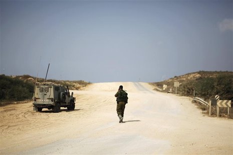 An Israeli soldier walks beside a military vehicle near the border with the northern Gaza Strip October 22, 2012. REUTERS/Amir Cohen An Israeli soldier walks beside a military vehicle near the border with the northern Gaza Strip October 22, 2012. REUTERS/Amir Cohen