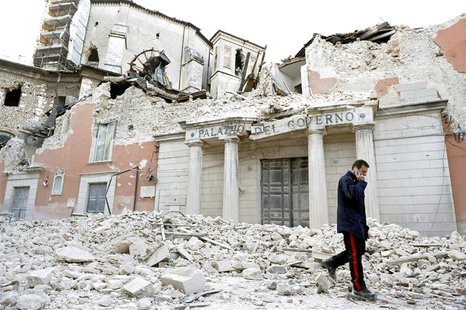 An Italian military carabinieri walks on debris past destroyed buildings after an earthquake, in downtown Aquila, in this April 6, 2009 file An Italian military carabinieri walks on debris past destroyed buildings after an earthquake, in downtown Aquila, in this April 6, 2009 file