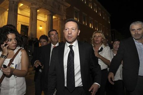 Greek Finance Minister Yannis Stournaras (C) walks between reporters outside the parliament following long talks with the troika in Athens O Greek Finance Minister Yannis Stournaras (C) walks between reporters outside the parliament following long talks with the troika in Athens O