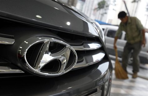 The logo of Hyundai Motor is seen on the on a car as a worker sweeps a floor at a Hyundai dealership in Seoul October 25, 2012. REUTERS/Kim The logo of Hyundai Motor is seen on the on a car as a worker sweeps a floor at a Hyundai dealership in Seoul October 25, 2012. REUTERS/Kim