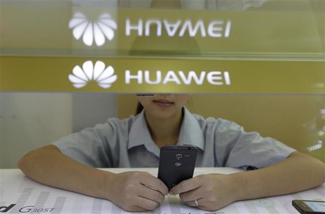 A sales assistant looks at her mobile phone as she waits for customers behind a counter at a Huawei booth in Wuhan, Hubei province, October A sales assistant looks at her mobile phone as she waits for customers behind a counter at a Huawei booth in Wuhan, Hubei province, October