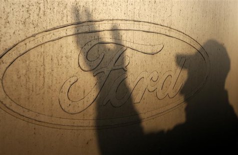 The shadow of a worker is seen on the logo of Ford Motor Co at the company's assembly plant after an emergency meeting with the plant manage The shadow of a worker is seen on the logo of Ford Motor Co at the company's assembly plant after an emergency meeting with the plant manage
