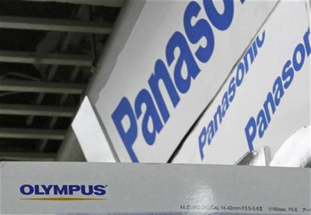 Olympus Corp (bottom) and Panasonic Corp logos are seen at an electronics store in Tokyo June 7, 2012. REUTERS/Toru Hanai Olympus Corp (bottom) and Panasonic Corp logos are seen at an electronics store in Tokyo June 7, 2012. REUTERS/Toru Hanai