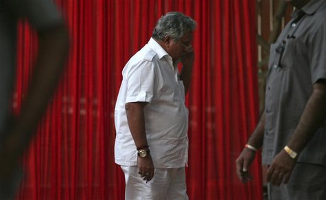 Kingfisher Airlines Chairman Vijay Mallya speaks on a mobile phone amid his security personnel on guard during a meeting with the debt-laden Kingfisher Airlines Chairman Vijay Mallya speaks on a mobile phone amid his security personnel on guard during a meeting with the debt-laden