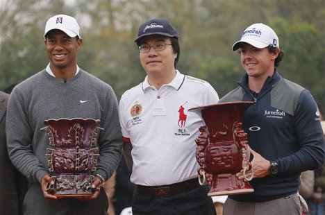 Rory McIlroy (R) of Northern Ireland holds the winner's trophy as he poses with Tiger Woods (L) of the U.S. and Feng Changge, Chairman of He Rory McIlroy (R) of Northern Ireland holds the winner's trophy as he poses with Tiger Woods (L) of the U.S. and Feng Changge, Chairman of He