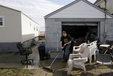 Mike Starkie sweeps mud out of his garage as he cleans up from Hurricane Sandy in Fairhaven, Massachusetts October 30, 2012. REUTERS/Jessica Mike Starkie sweeps mud out of his garage as he cleans up from Hurricane Sandy in Fairhaven, Massachusetts October 30, 2012. REUTERS/Jessica