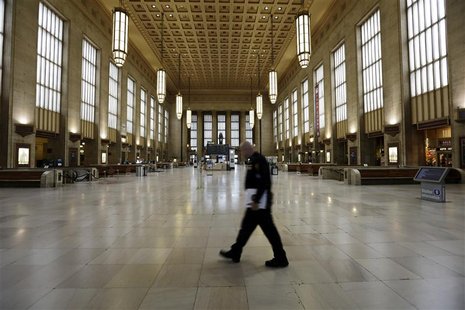 An Amtrak police officer patrols the empty 30th Street Station after all rail travel was cancelled due to damage caused by Hurricane Sandy i An Amtrak police officer patrols the empty 30th Street Station after all rail travel was cancelled due to damage caused by Hurricane Sandy i
