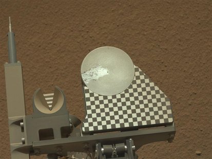 A sample of Martian soil delivered by the robotic arm on NASA's Mars rover Curiosity to the rover's observation tray for the first time is p A sample of Martian soil delivered by the robotic arm on NASA's Mars rover Curiosity to the rover's observation tray for the first time is p