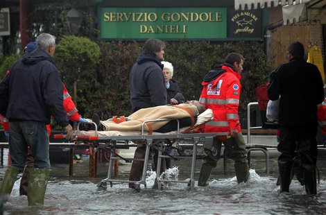 Nurses carry a man on a stretcher in a flooded street during a period of seasonal high water in Venice November 1, 2012. REUTERS/Manuel Silv Nurses carry a man on a stretcher in a flooded street during a period of seasonal high water in Venice November 1, 2012. REUTERS/Manuel Silv