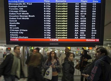 Travellers surround a flight monitor showing cancelled flights at LaGuardia airport in New York October 28, 2012. REUTERS/Adrees Latif Travellers surround a flight monitor showing cancelled flights at LaGuardia airport in New York October 28, 2012. REUTERS/Adrees Latif