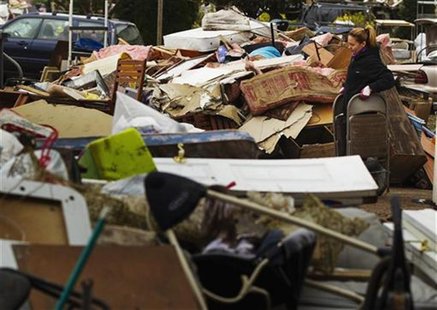 A woman carries flood damaged furniture from her home to throw onto the street in the New Dorp Beach neighborhood of the Staten Island borou A woman carries flood damaged furniture from her home to throw onto the street in the New Dorp Beach neighborhood of the Staten Island borou