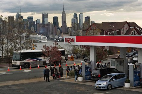 People wait in line to buy gas at a station, as the Empire State Building and the skyline of New York is seen in the background, at Union Ci People wait in line to buy gas at a station, as the Empire State Building and the skyline of New York is seen in the background, at Union Ci